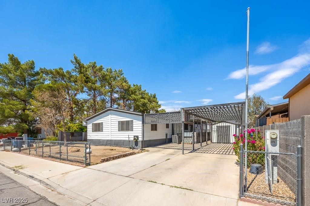 1208 Inca Lane Henderson, NV 89015 - Photo 2 of 21 Manufactured / mobile home featuring a gate, a fenced front yard, and a patio area