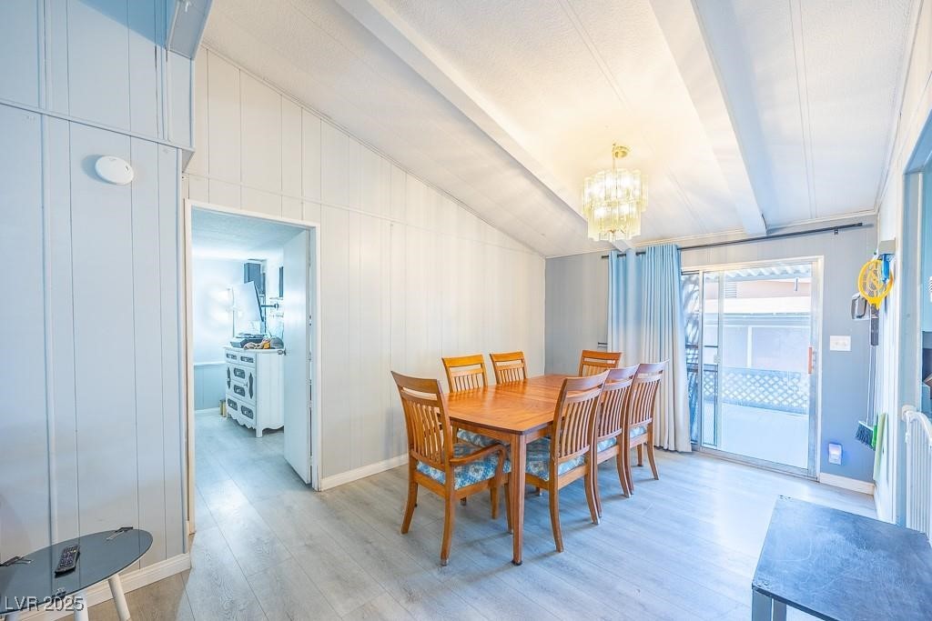 1208 Inca Lane Henderson, NV 89015 - Photo 9 of 21 Dining room with light wood-style floors, a chandelier, and wood walls