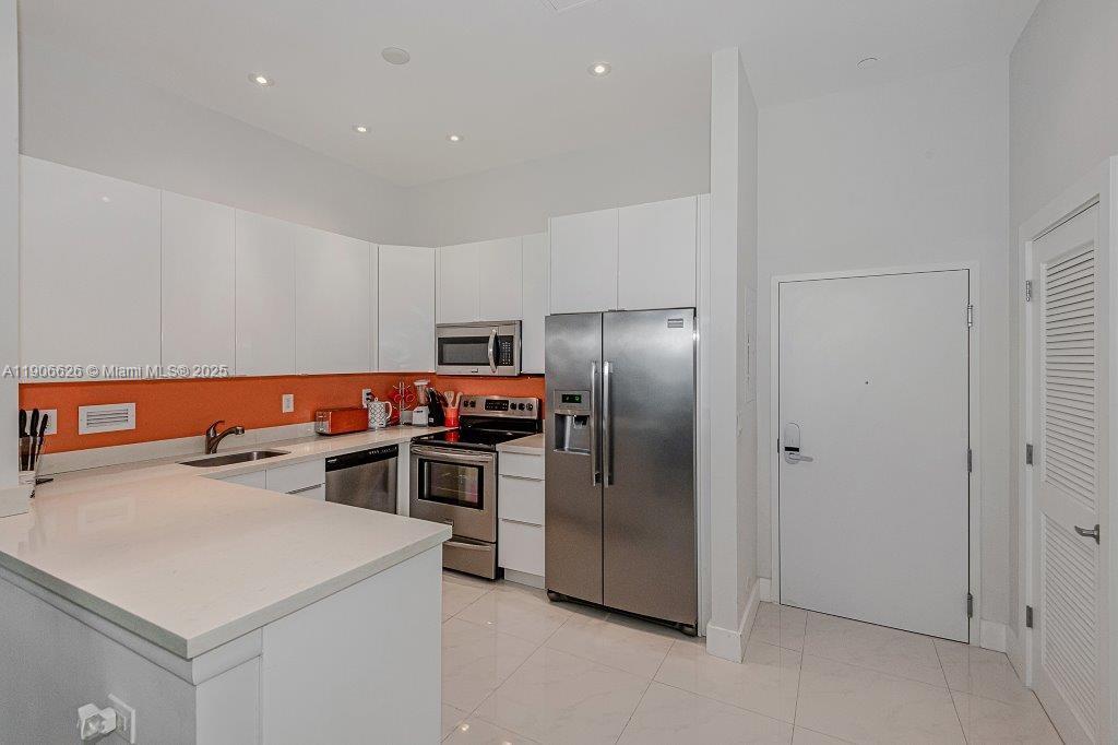 2301 Collins Avenue, Unit 1619 Miami Beach, FL 33139 - Photo 13 of 28 a kitchen with a refrigerator and a sink