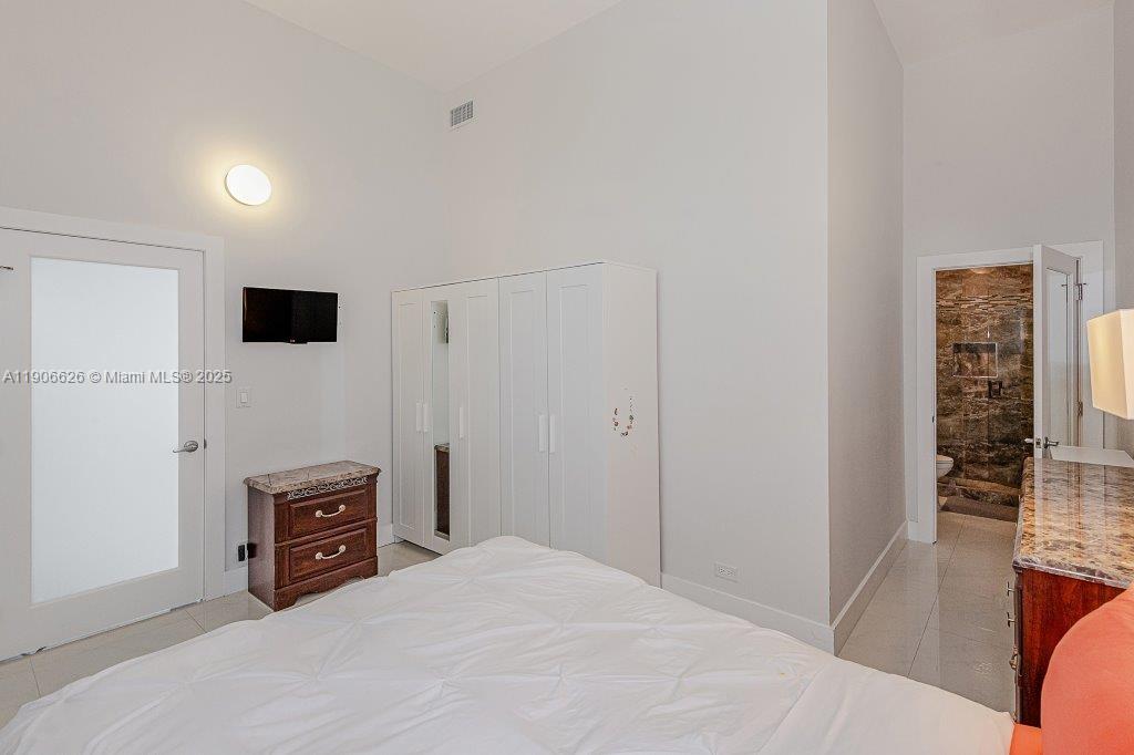 2301 Collins Avenue, Unit 1619 Miami Beach, FL 33139 - Photo 24 of 28 a bedroom with a bed and a television