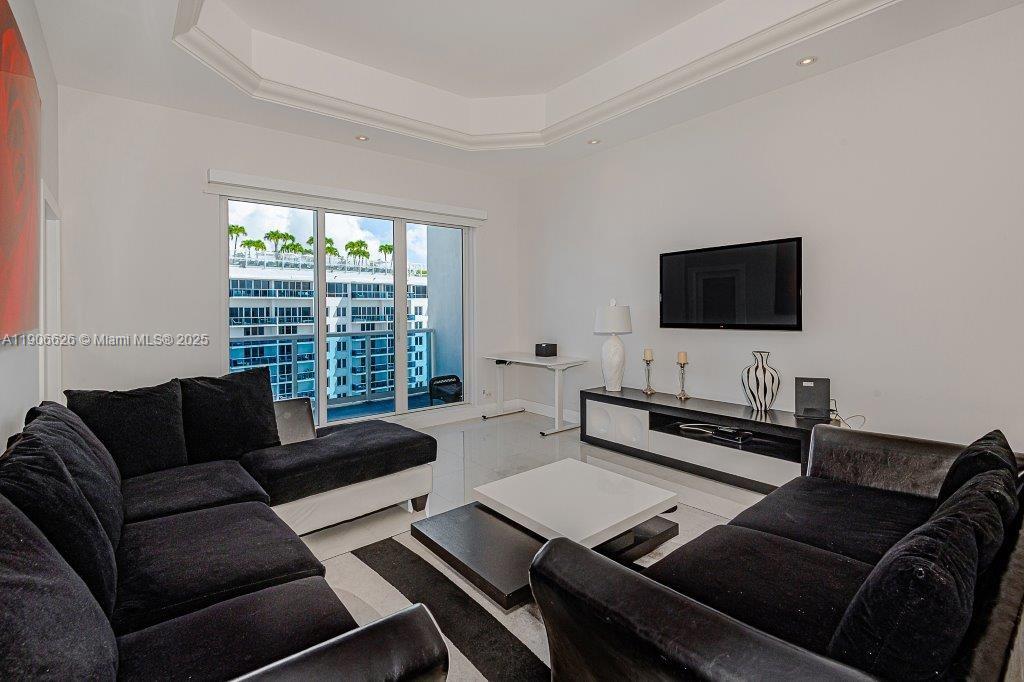 2301 Collins Avenue, Unit 1619 Miami Beach, FL 33139 - Photo 7 of 28 a living room with furniture and a flat screen tv