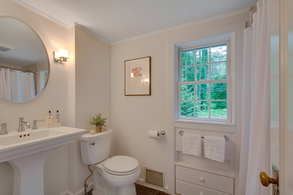 24 Beaver Pond Road Lincoln, MA 01773 - Photo 24 of 35 a bathroom with a toilet a sink a mirror a window and vanity
