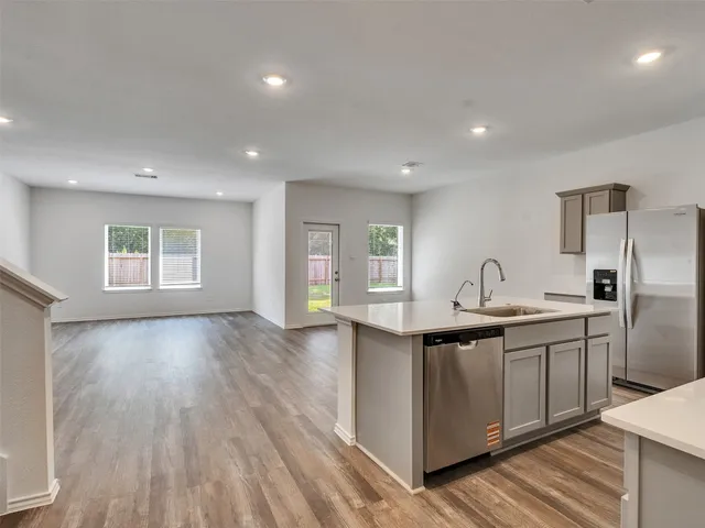 a kitchen with stainless steel appliances granite countertop a sink and wooden floors