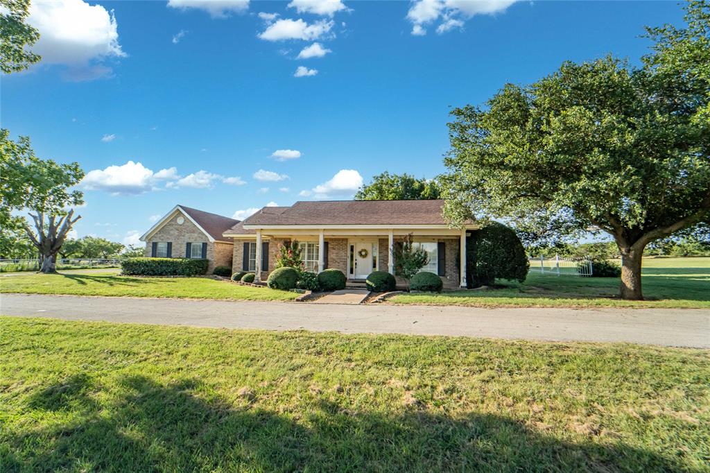 Single story home featuring a front lawn, a porch, and brick siding