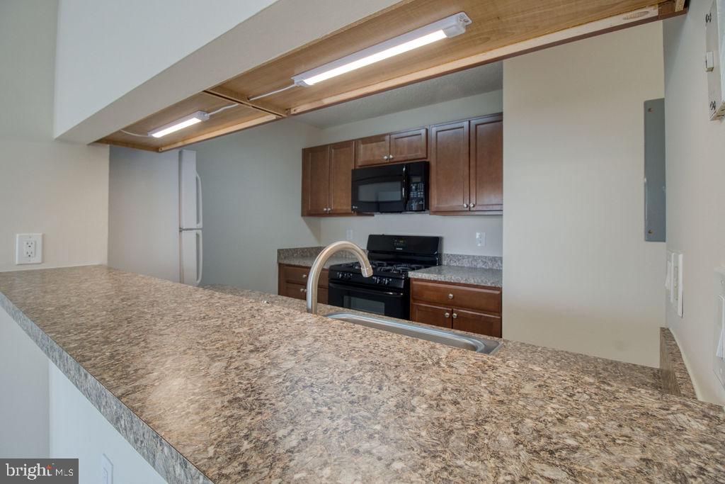 21024 Timber Ridge Terrace, Unit 303 Ashburn, VA 20147 - Photo 8 of 42 Kitchen Breakfast Bar Open To Living Room