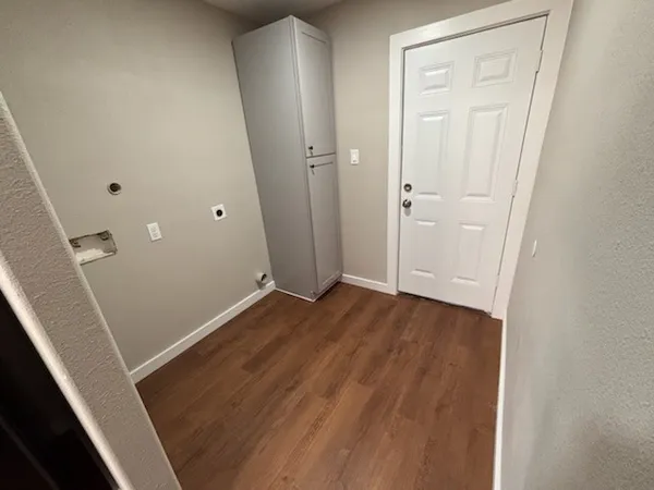 an empty room with wooden floor and entrance