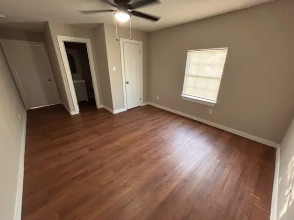 an empty room with wooden floor and windows