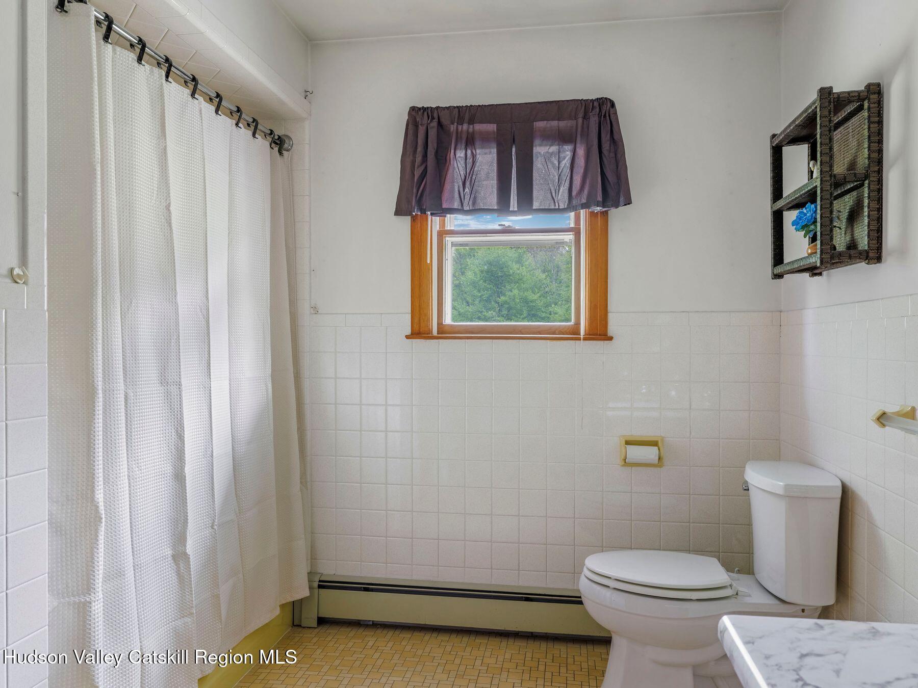 104 New Paltz Road Highland, NY 12528 - Photo 15 of 43 a bathroom with a toilet and a shower curtain