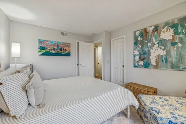a bedroom with a bed and a painting on the wall