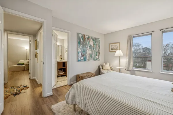 a bedroom with a balcony a bed and a large window