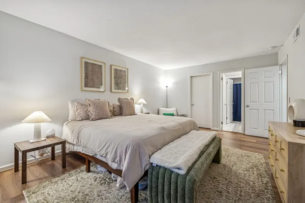 a spacious bedroom with a bed and a lamp