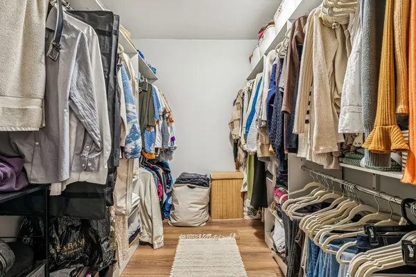 a view of walk in closet with clothes