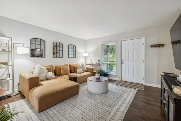 a living room with furniture and wooden floor