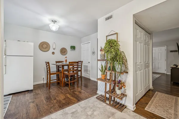 a view of a dining room and livingroom with furniture wooden floor a rug a chandelier and a rug