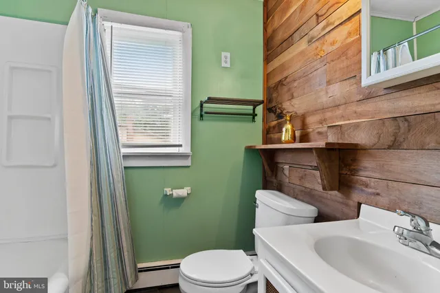 a bathroom with a sink a toilet and mirror