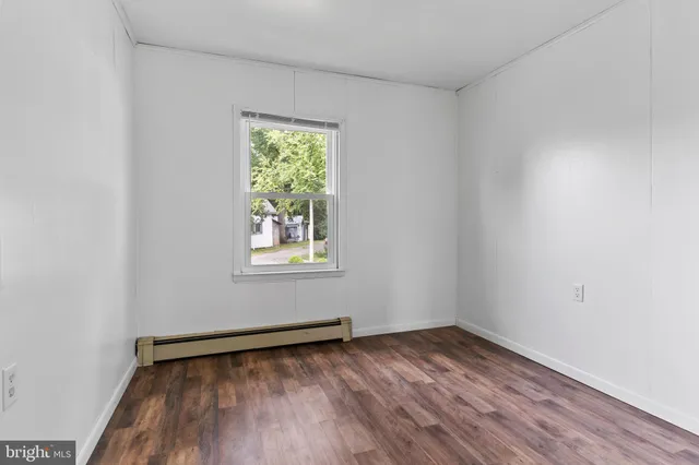 a view of a room with wooden floor and window