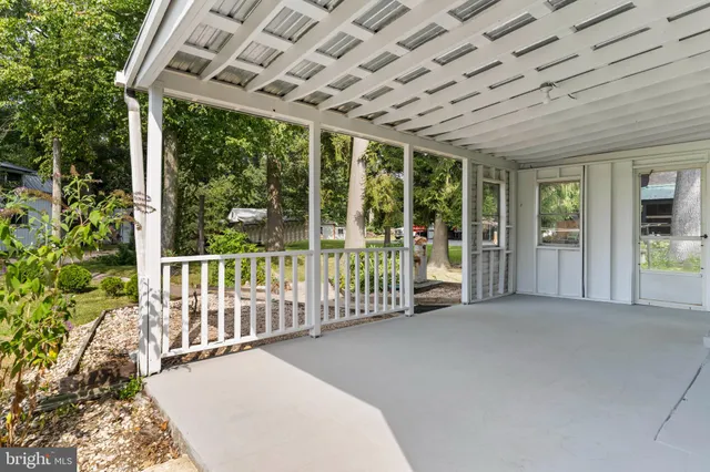a view of a porch with wooden floor and roof with floor to ceiling window