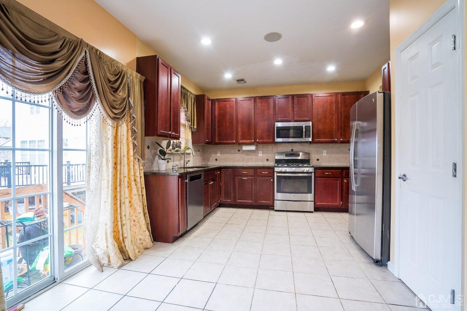 8 Maxwell Road Monroe Township, NJ 08831 - Photo 8 of 40 a kitchen with stainless steel appliances granite countertop a stove a sink and a refrigerator