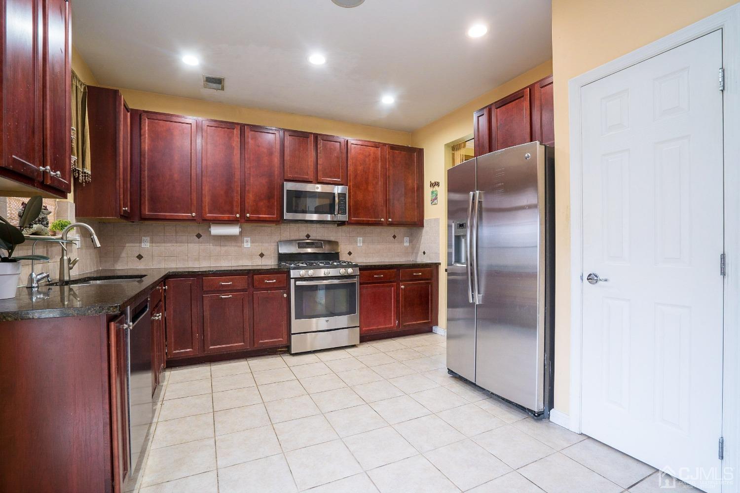 8 Maxwell Road Monroe Township, NJ 08831 - Photo 9 of 40 a kitchen with stainless steel appliances granite countertop a refrigerator sink and stove