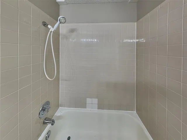 a bathroom with a bath tub with a shower