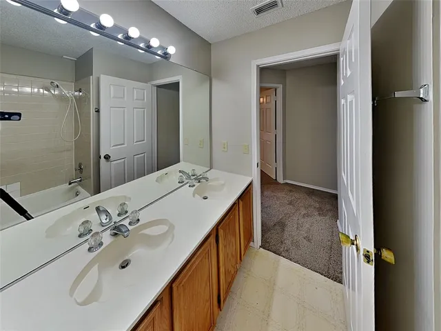 a bathroom with a double vanity sink mirror and shower