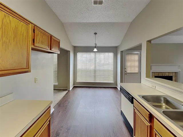 a kitchen with granite countertop a sink and a refrigerator