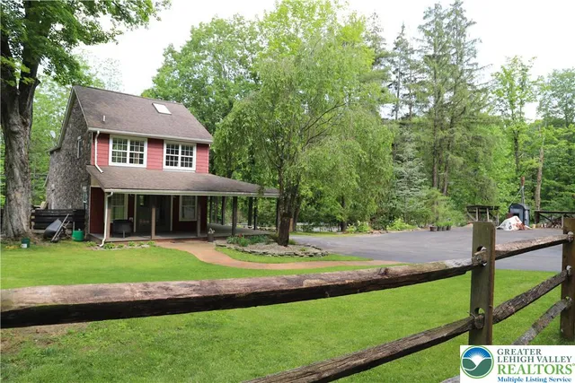 a front view of a house with a yard and green space
