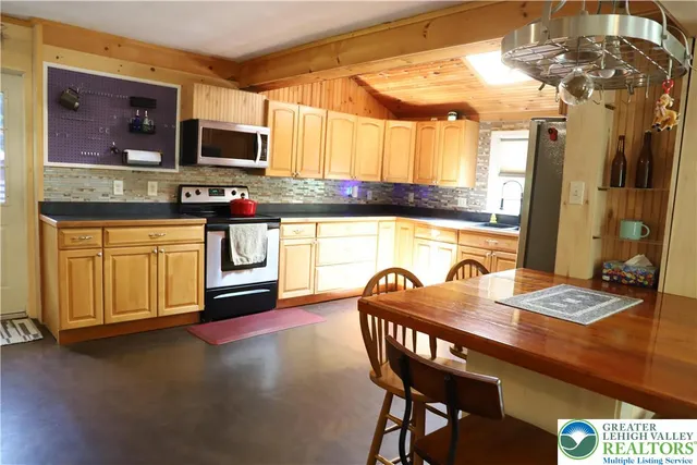 a kitchen with a table chairs microwave and refrigerator