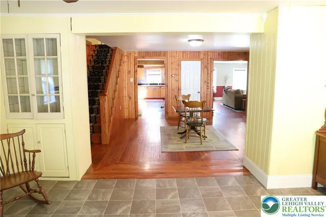 a view of a living room with a floor to ceiling window and wooden floor