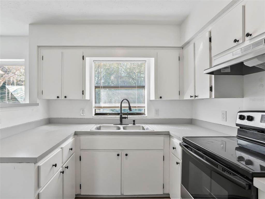 5911 Northwest 9th Street Ocala, FL 34482 - Photo 12 of 37 a kitchen with a sink stove top oven and cabinets