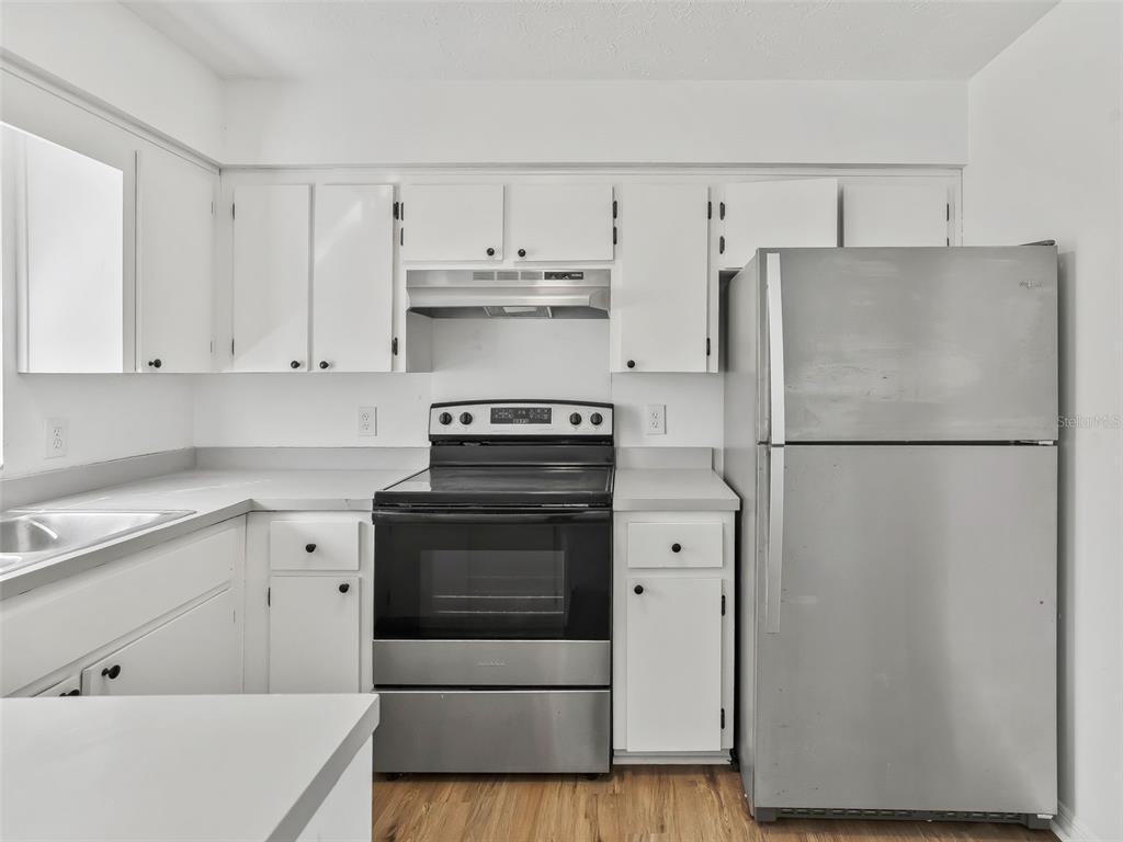5911 Northwest 9th Street Ocala, FL 34482 - Photo 13 of 37 a kitchen with cabinets appliances and wooden floor