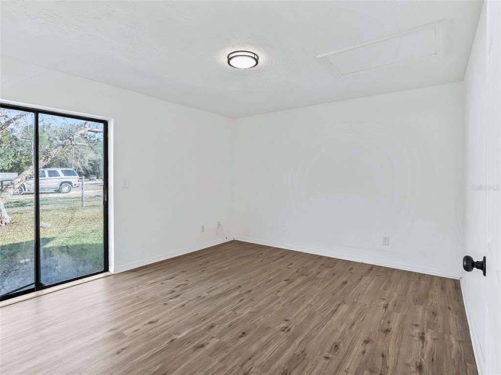5911 Northwest 9th Street Ocala, FL 34482 - Photo 16 of 37 a view of an empty room with wooden floor and a window