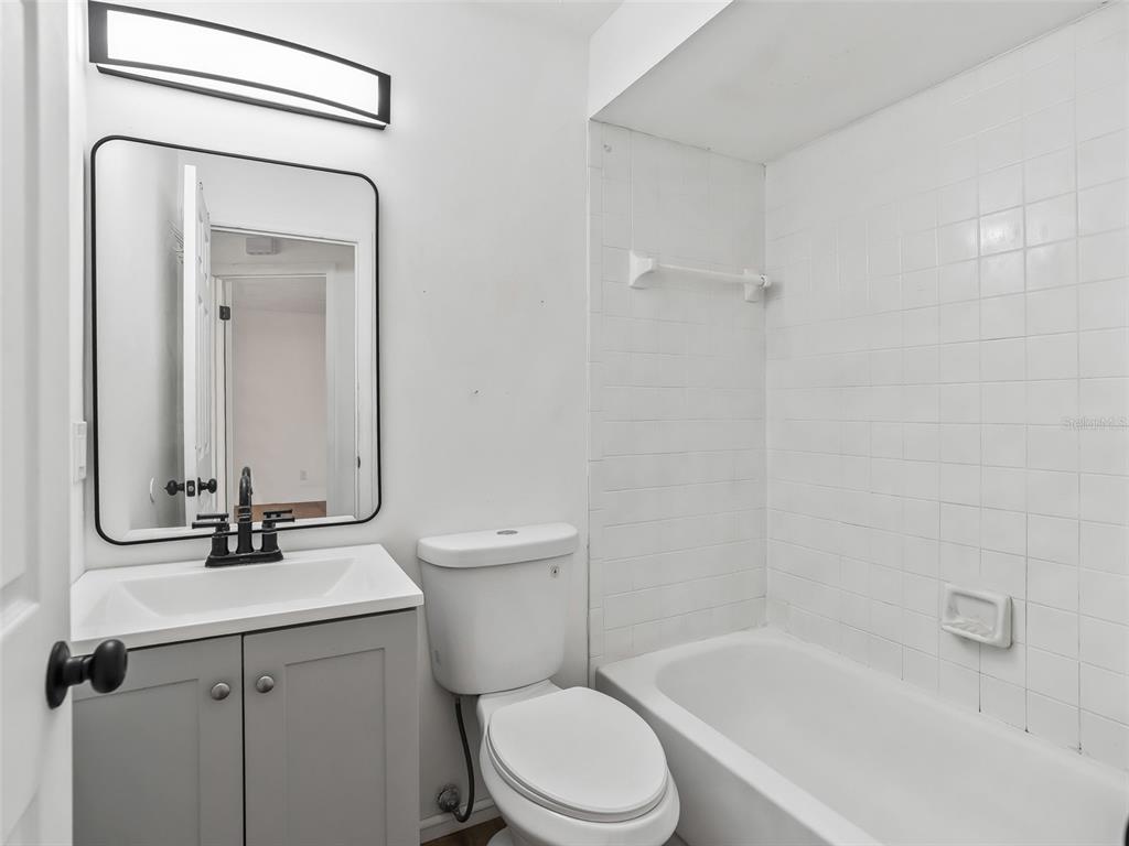 5911 Northwest 9th Street Ocala, FL 34482 - Photo 20 of 37 a bathroom with a toilet sink vanity tub and mirror