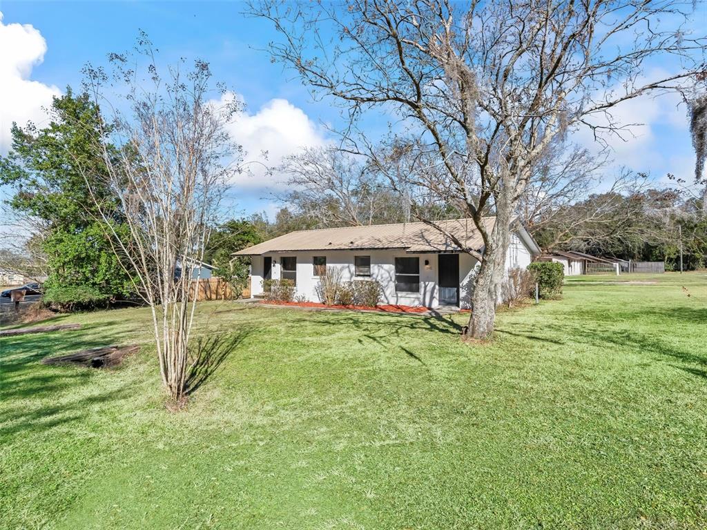 5911 Northwest 9th Street Ocala, FL 34482 - Photo 2 of 37 a backyard of a house with table and chairs