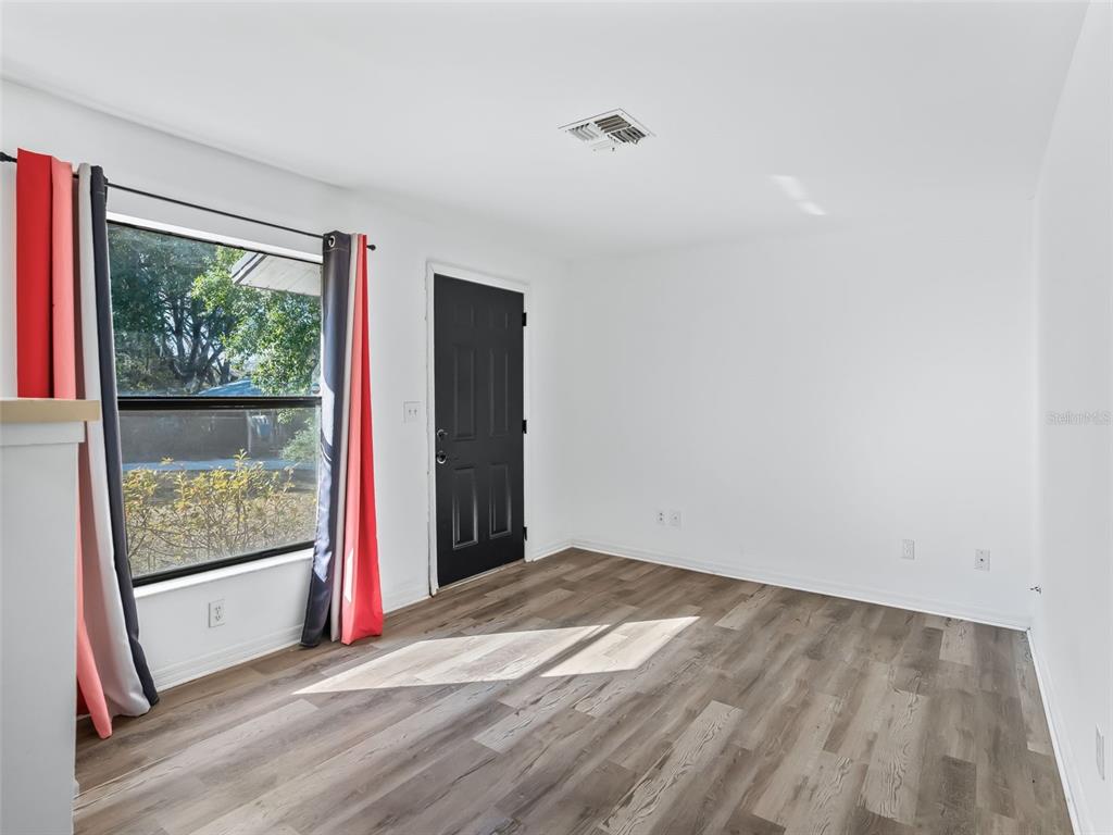 5911 Northwest 9th Street Ocala, FL 34482 - Photo 23 of 37 a view of an empty room with wooden floor and a window