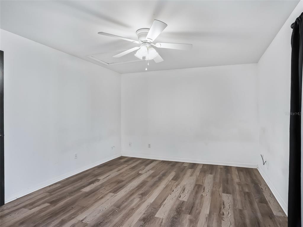 5911 Northwest 9th Street Ocala, FL 34482 - Photo 30 of 37 a view of a room with wooden floor and a ceiling fan