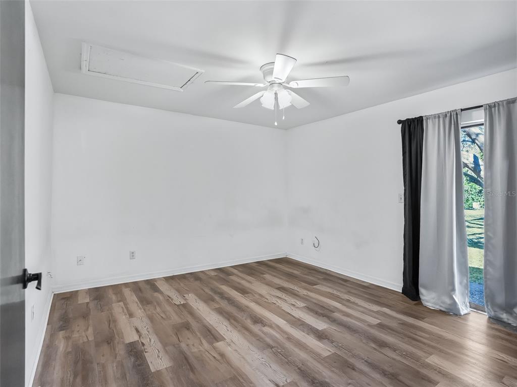 5911 Northwest 9th Street Ocala, FL 34482 - Photo 31 of 37 an empty room with wooden floor fan and windows