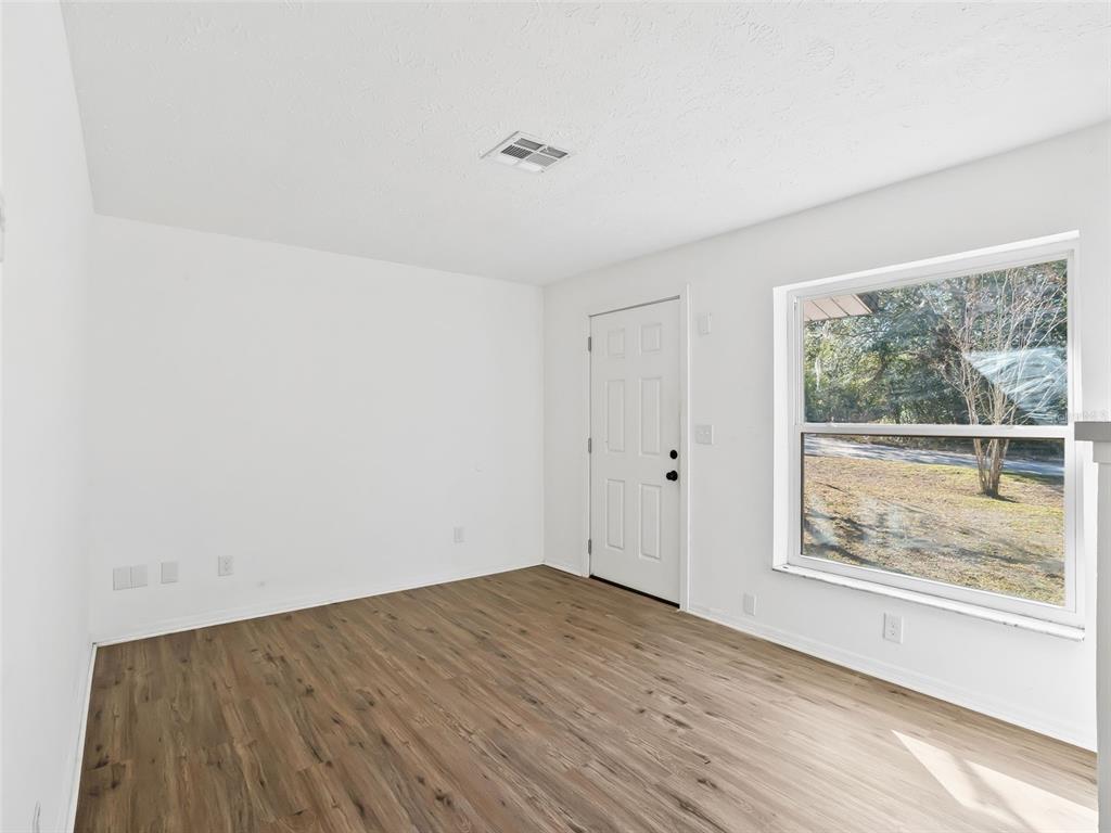 5911 Northwest 9th Street Ocala, FL 34482 - Photo 8 of 37 a view of an empty room with wooden floor and a window
