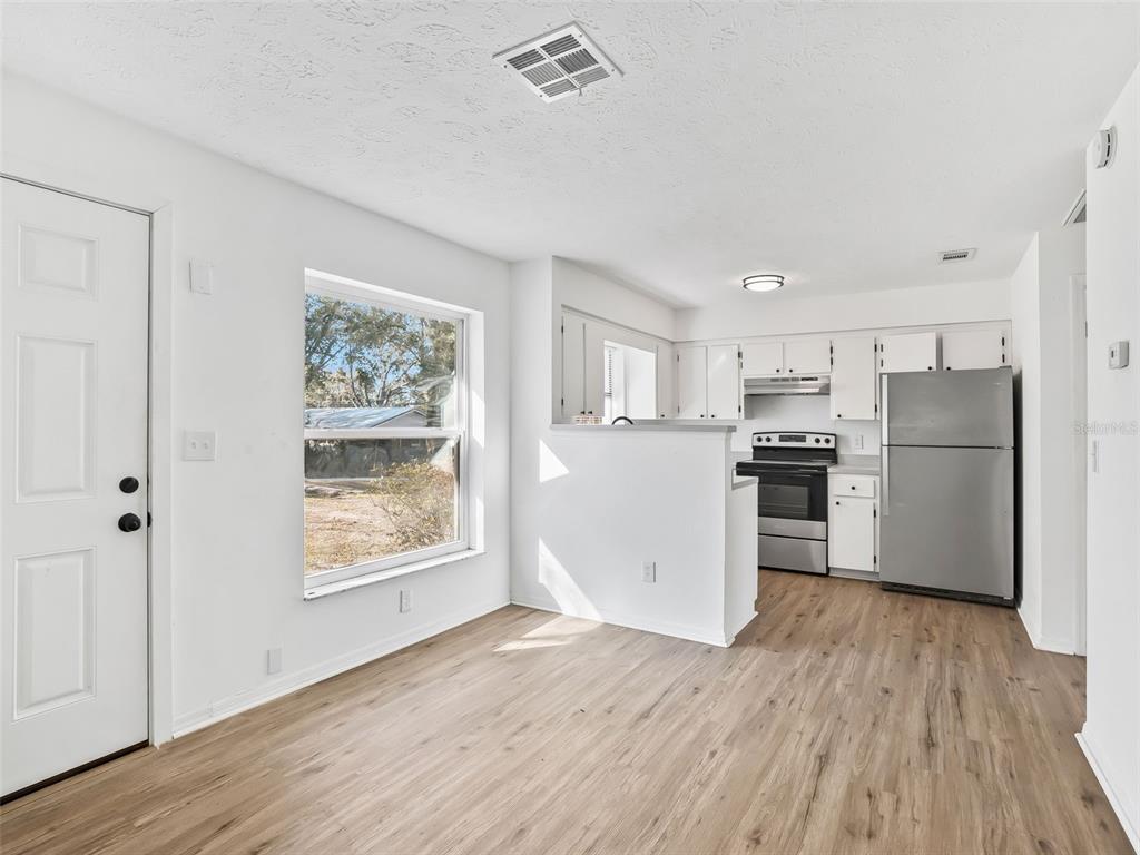 5911 Northwest 9th Street Ocala, FL 34482 - Photo 10 of 37 a kitchen with stainless steel appliances a refrigerator and wooden floor