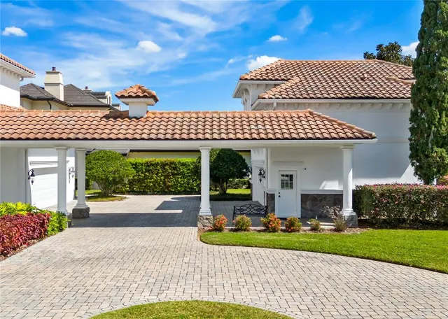 a front view of a house with a yard and potted plants