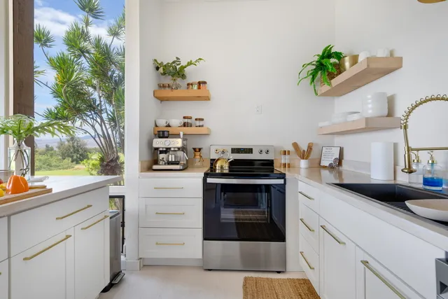 a kitchen with white cabinets and appliances