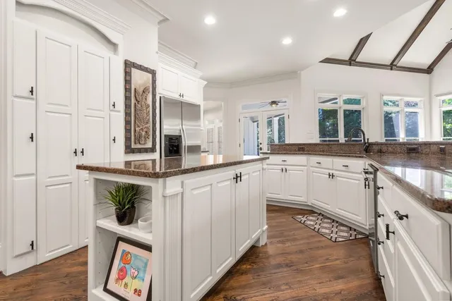 a kitchen with white cabinets and sink