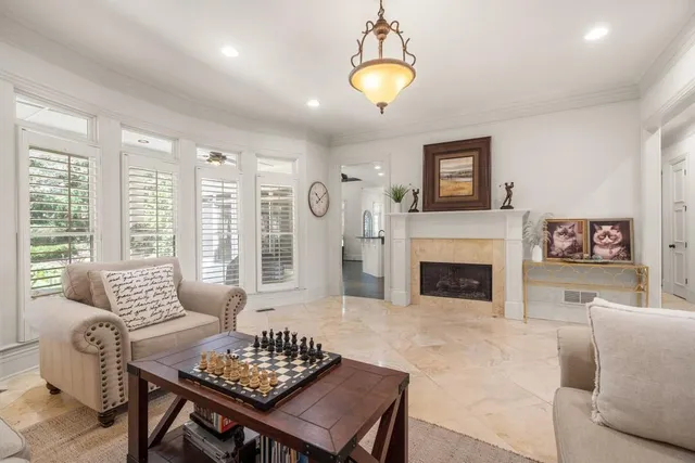 a living room with furniture a fireplace and a large window