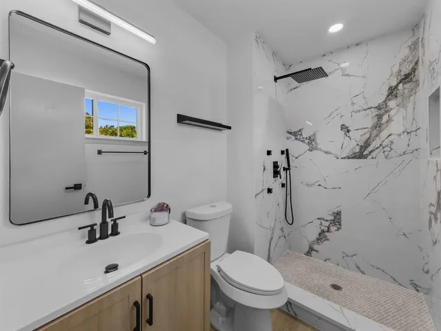 a bathroom with a sink toilet and shower