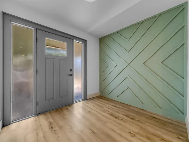 an empty room with wooden floor and door
