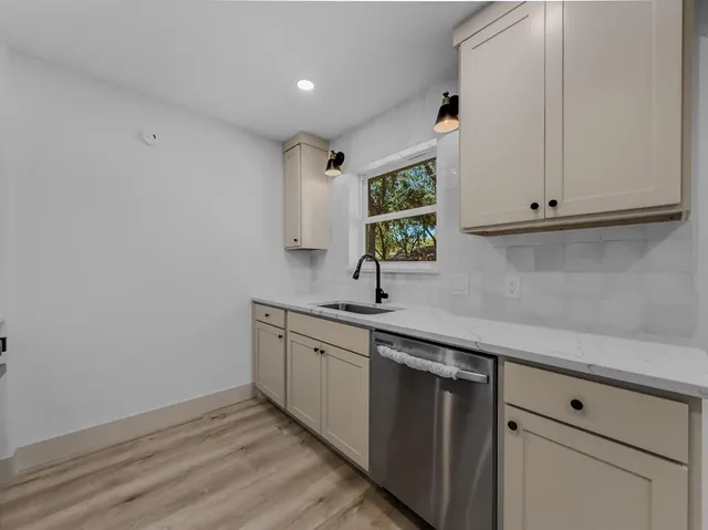 a kitchen with a sink cabinets and a window