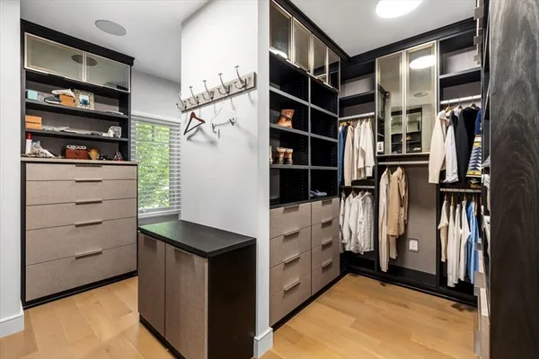 a view of walk in closet with clothes and shoes