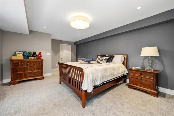 a bedroom with a bed and a lamp on dresser