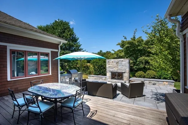 a view of a patio with table and chairs potted plants with wooden floor and fence