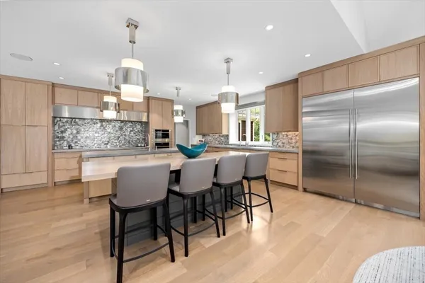 a kitchen with a dining table chairs and refrigerator